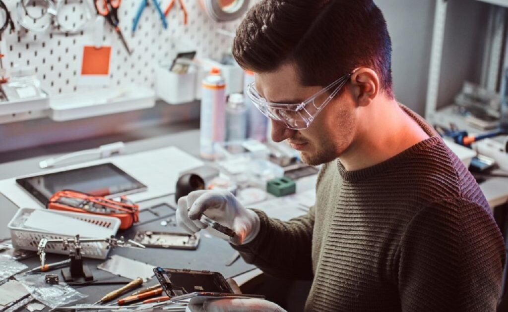 Un homme entrain de réparer un smartphone