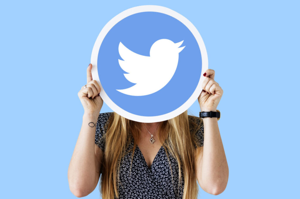 Une femme montrant le logo de Twitter.